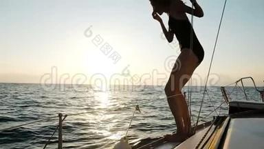 夕阳西下，瘦漂亮的女孩从游艇上跳入开阔的大海，慢动作